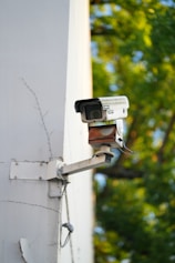 Security camera mounted on a white building wall.