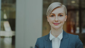 A professional woman in a suit smiles confidently.