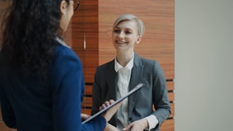 Two women in business attire talking