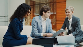Three professionals discussing documents at a table.