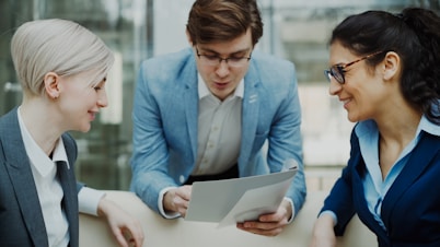 Three professionals discussing a document together