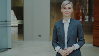 A professional woman in a suit smiling confidently.