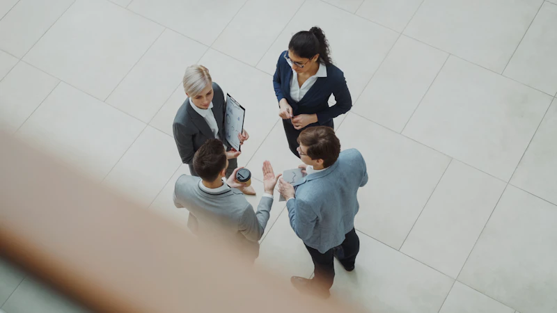 Group of business professionals talking in a modern office lobby
