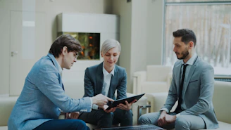 Three professionals discussing a tablet in a modern office