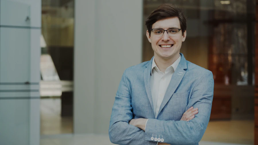 Man in a light blue suit with glasses
