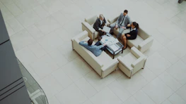 Business people meeting on sofas in a modern lobby.