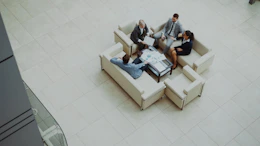 Business people meeting on sofas in a modern lobby.