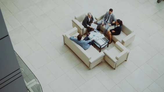 Business people meeting on sofas in a modern lobby.