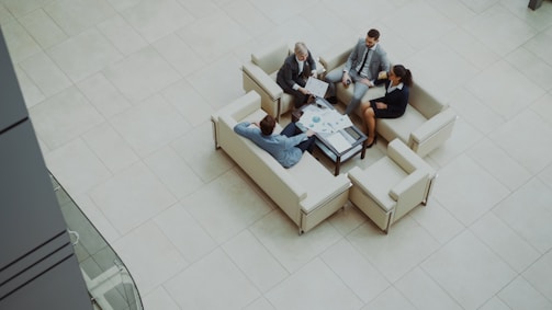 Business people meeting on sofas in a modern lobby.