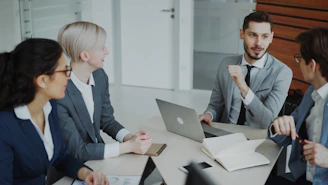 Four professionals in a business meeting around a table