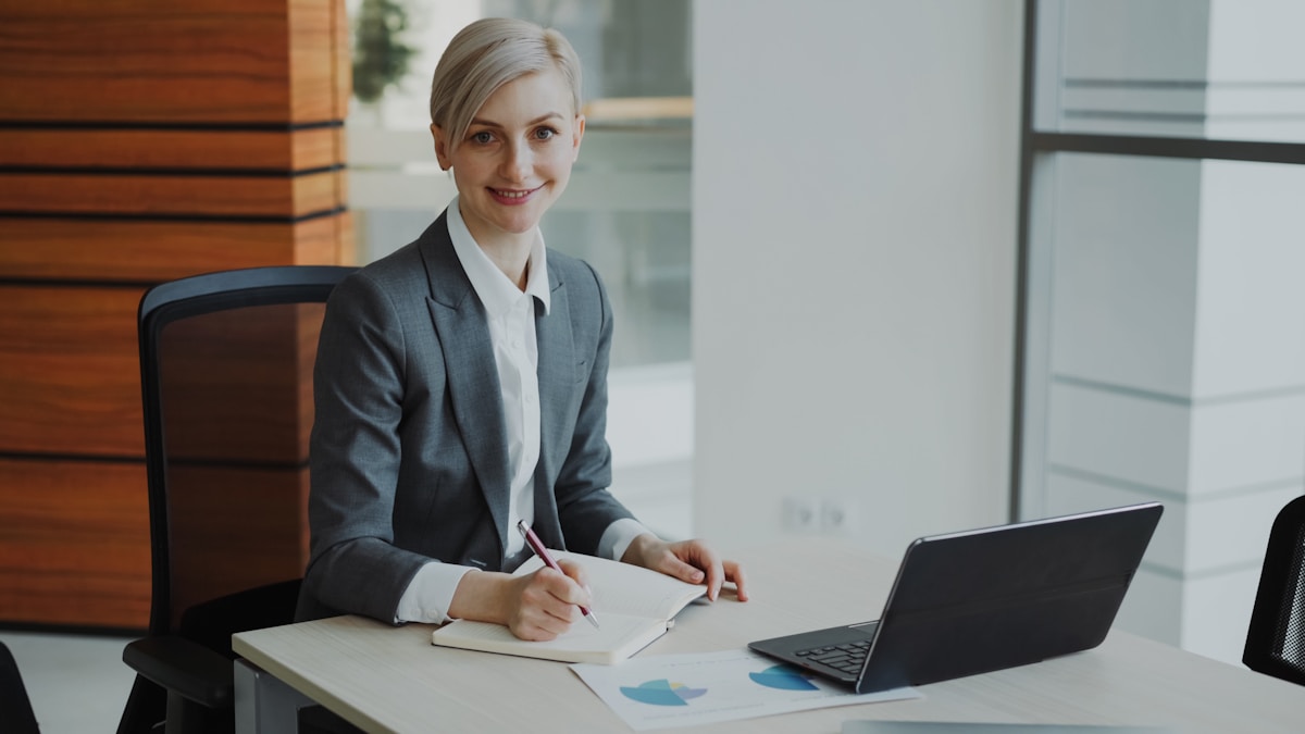 a-professional-woman-in-a-suit-works-at-a-desk-KKJOQg5grhQ collection background image