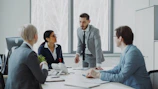 Business professionals in a meeting around a table.