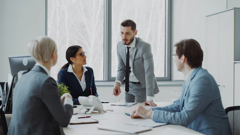 Business professionals in a meeting around a table.