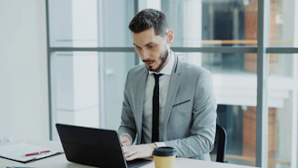 Man in suit working on a laptop at desk
