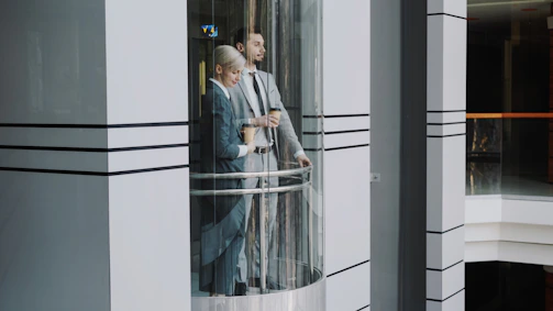 Two business people in a glass elevator