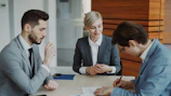 Business people signing a contract at a table.