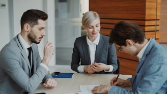 Business people signing a contract at a table.