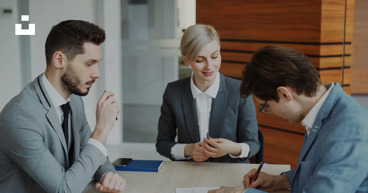 Two businesspeople signing a contract at a table in a professional office setting