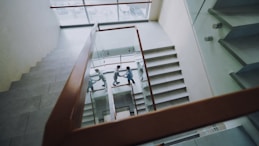 Three people climbing stairs in a modern building