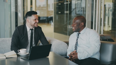 Two businessmen talking in a modern office setting.