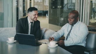 Two businessmen discussing documents over coffee