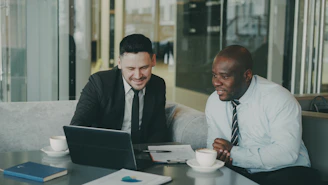 Two businessmen collaborating on a laptop.