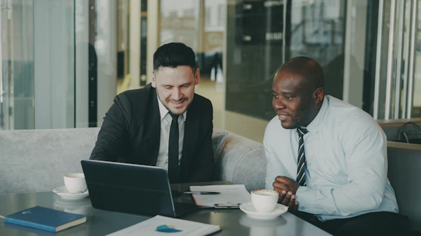 Two businessmen collaborating on a laptop.