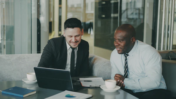 Two businessmen collaborating on a laptop.