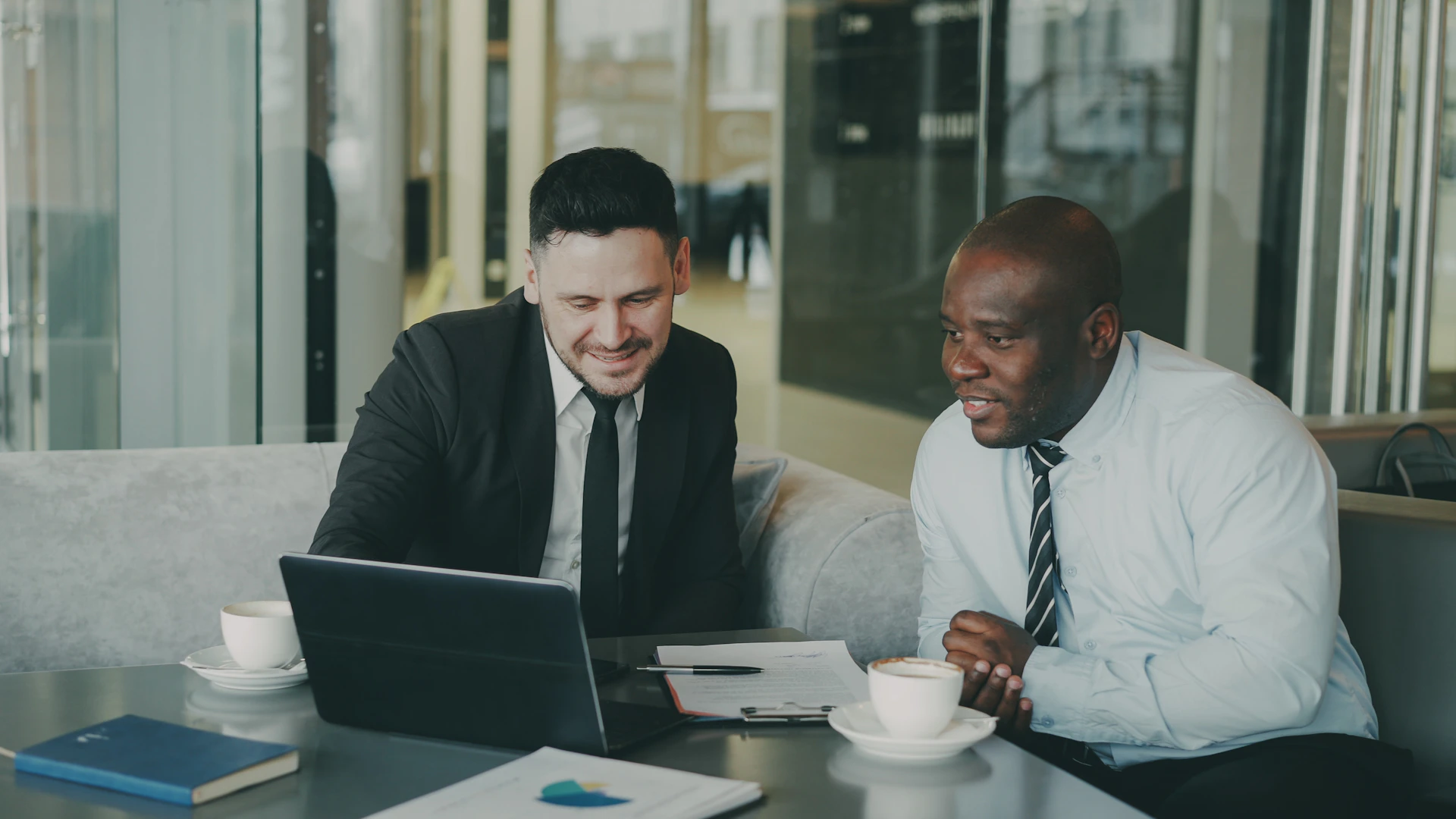 Two businessmen collaborating on a laptop.