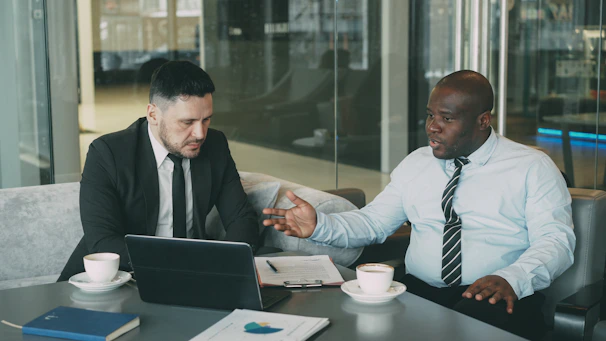Two businessmen discussing a project at a table.