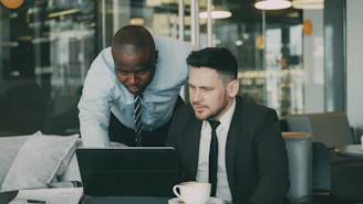 Two businessmen collaborating on a laptop