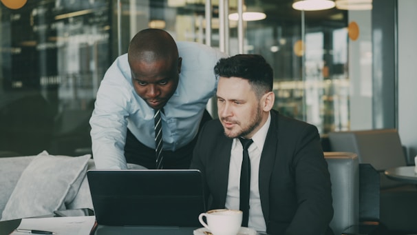 Two businessmen collaborating on a laptop