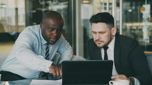 Two men looking at a laptop together