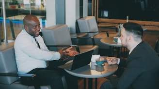 Two businessmen talking at a cafe table