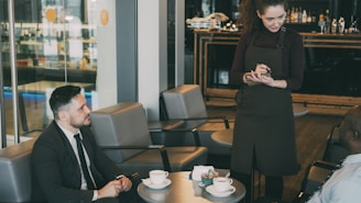 Waitress takes order from customers in cafe.