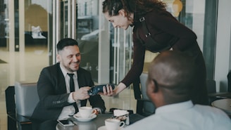 Man pays with credit card at cafe table