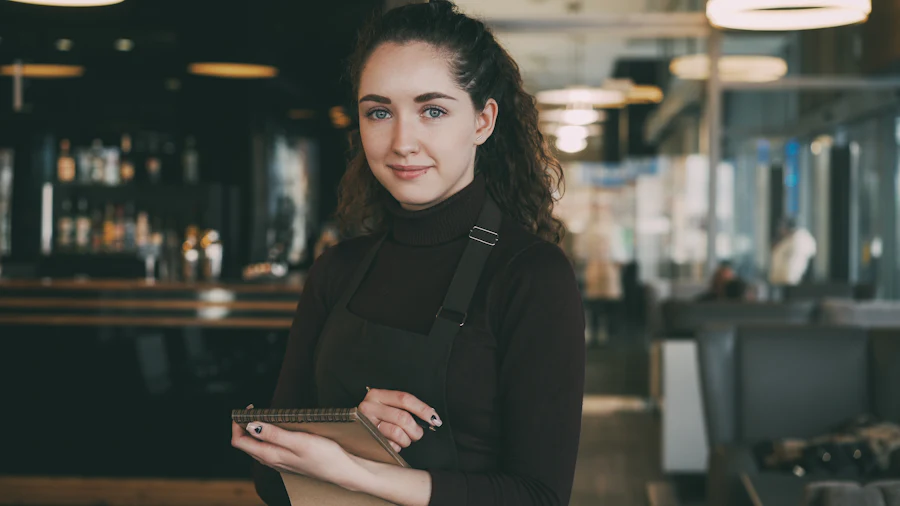 A restaurant host smiling at the front of the house