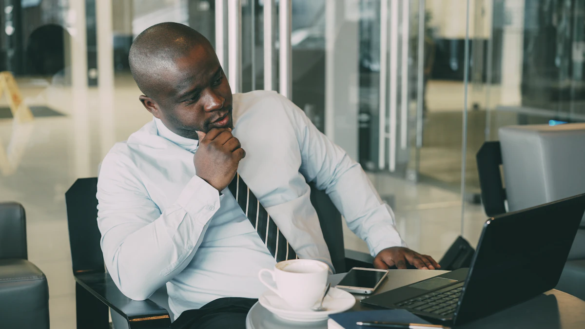 Man in shirt and tie working on laptop with coffee