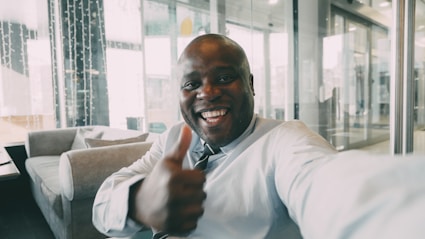 Man in a suit gives a thumbs up