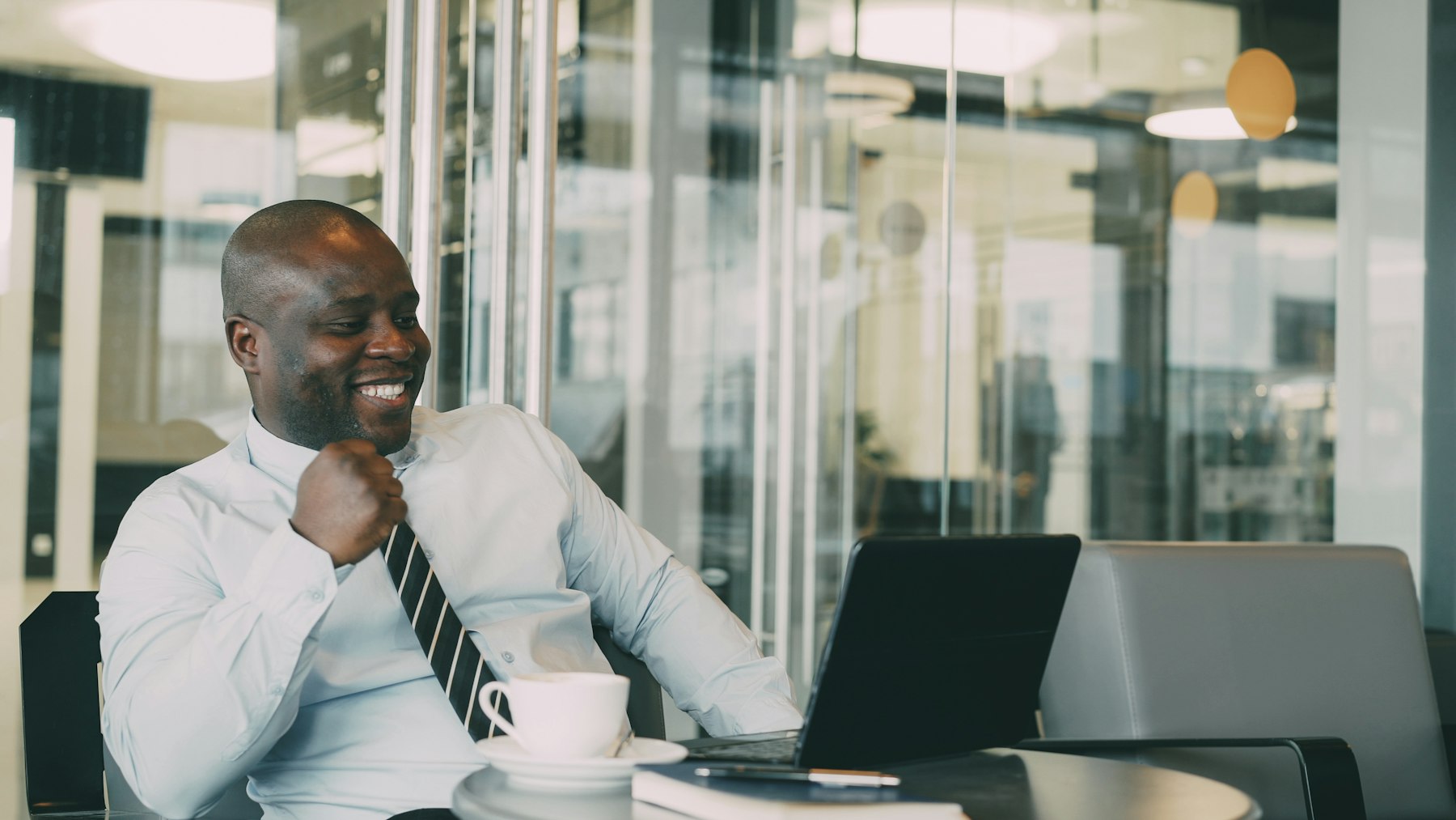 A professional sharing a laugh while working at his laptop