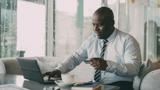Man in shirt and tie using laptop and credit card.
