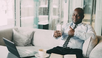 Man in suit giving thumbs up while video calling