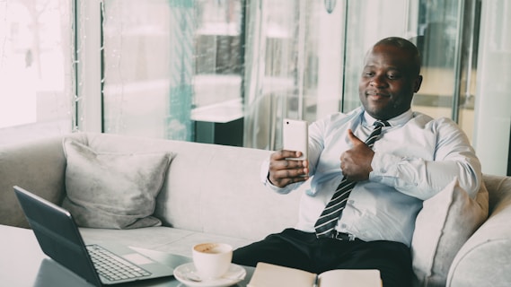 Man in suit giving thumbs up while video calling