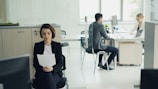 Woman sitting in office holding papers