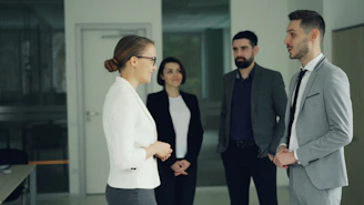 Business professionals conversing in a modern office hallway.