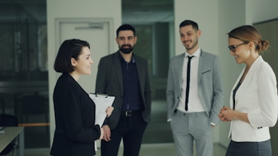 Four professionals in suits discussing in an office.
