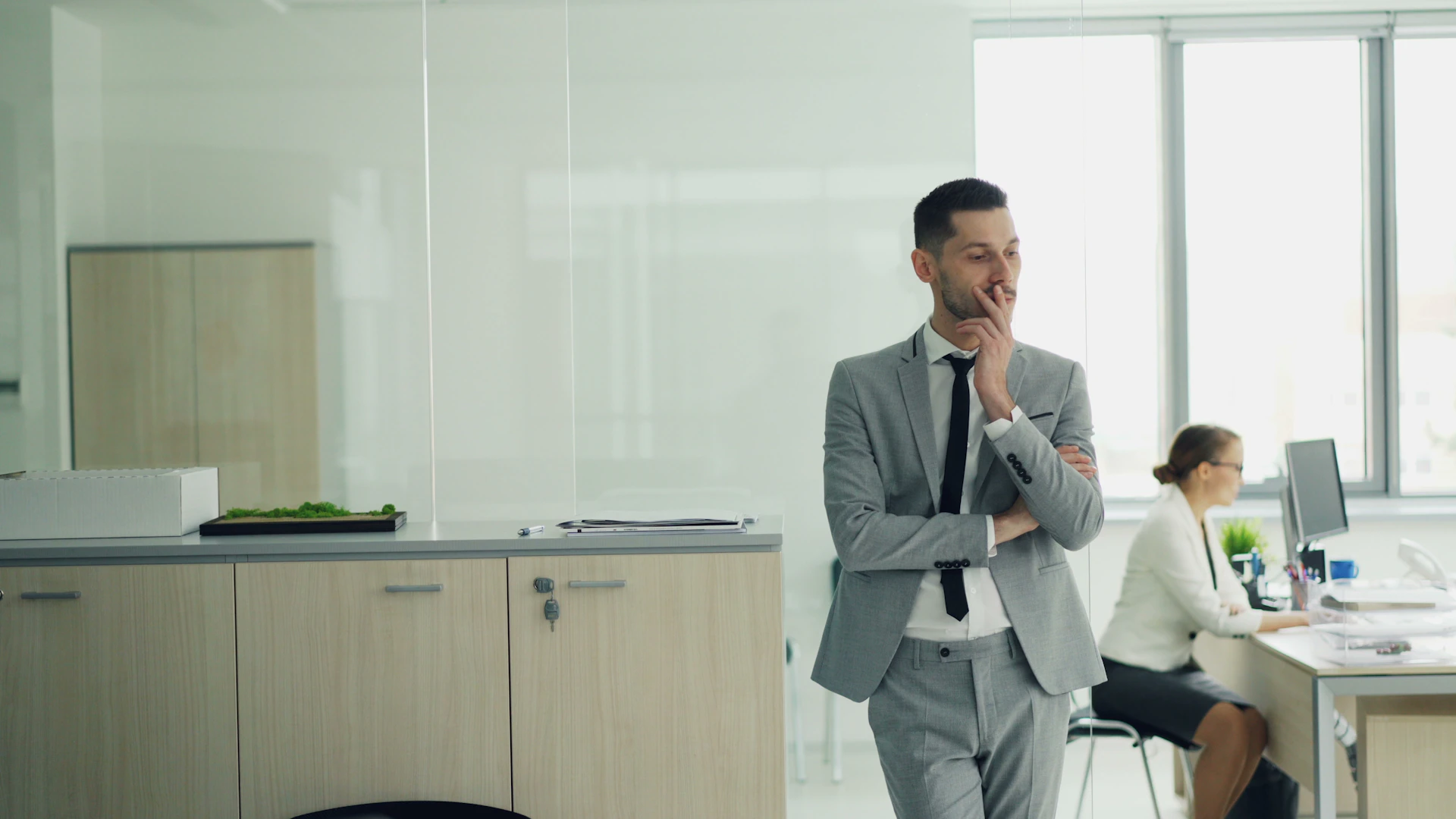 Man in suit thinking in modern office environment