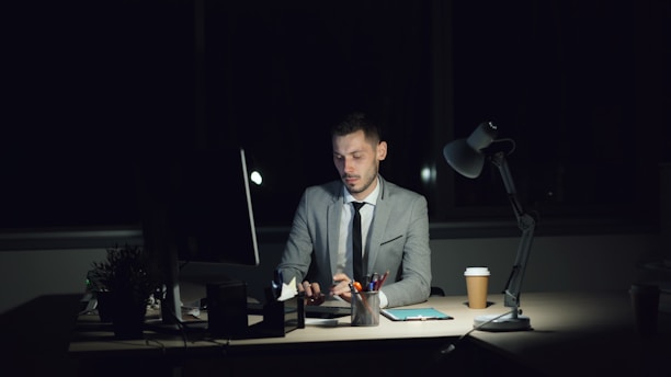 Man working late at his desk with coffee.