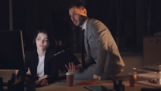 Two colleagues working late in a dimly lit office.