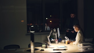 People working late in a dimly lit office.